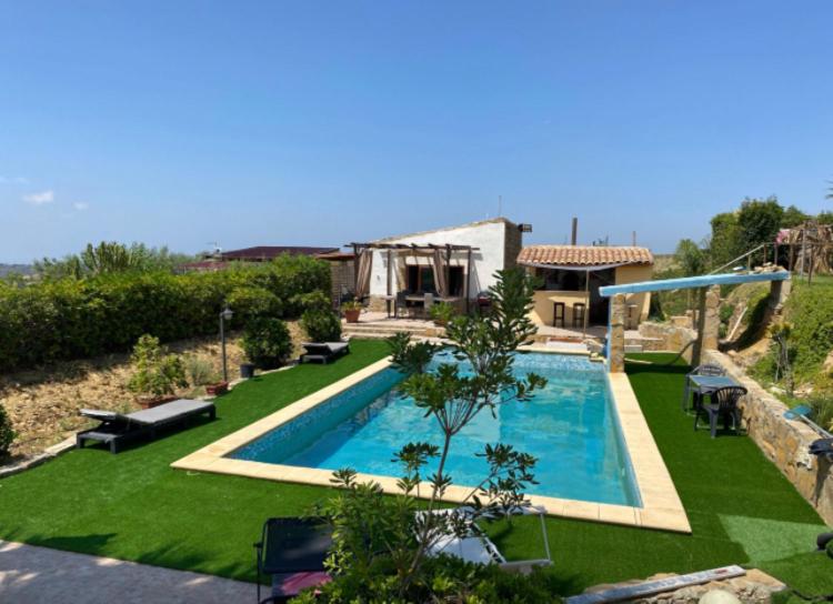 a swimming pool in the yard of a house at Villa Oliva Torotto in Niscemi