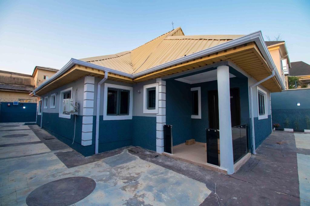 a blue and white house with a garage at Living Space Apartment in Ibadan