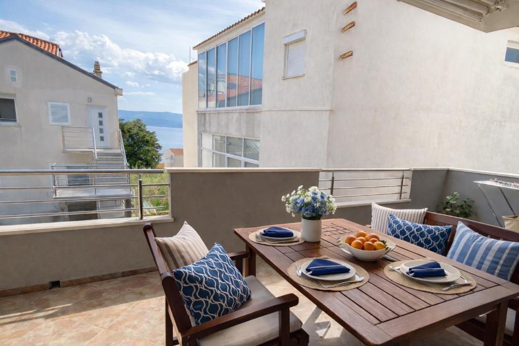 a wooden table and chairs on a balcony at Apartments Karla in Stanići