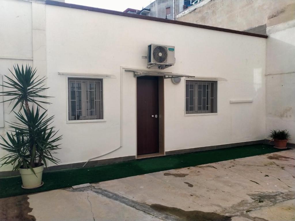 a white house with a door and a plant at Casa Vacanze ALeoFra in Taranto
