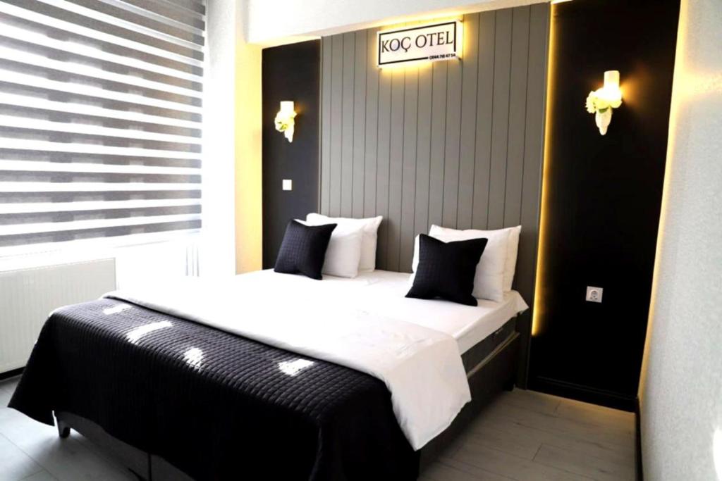 a large bed in a room with a sign on the wall at Koc Hotel in Karasu