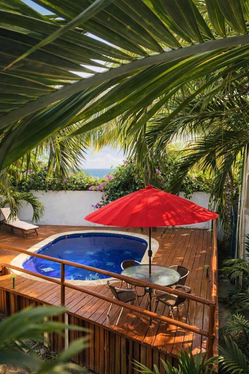 a table with a red umbrella next to a pool at Hotel Palmera Beach in Cartagena de Indias