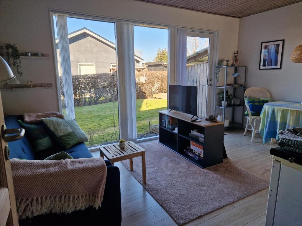 a living room with a large sliding glass door at Lillebo fred og ro in Græsted