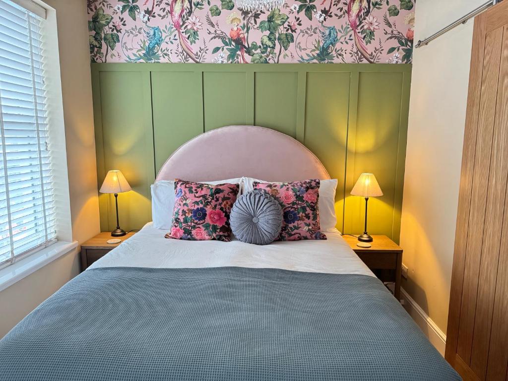 a bedroom with a bed with pillows and a headboard at Haven House Rooms, Barry in Barry