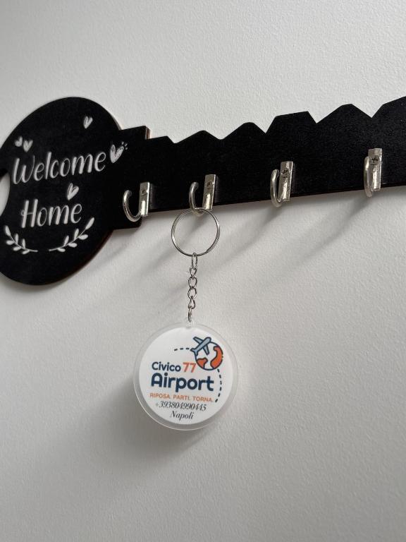 a key chain with a guitar keychain with the words welcome home at Civico77AirPort in Naples