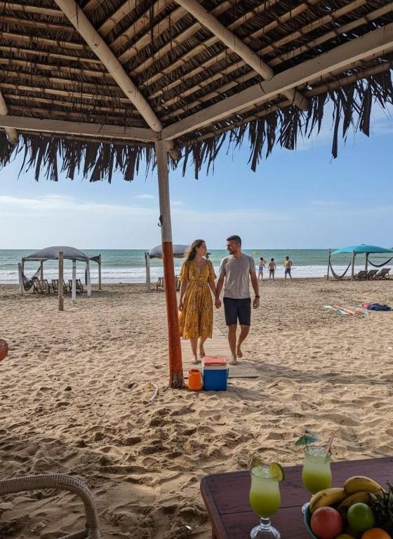 a man and a woman walking on the beach at departamento Vacacional, frente al mar in Playas