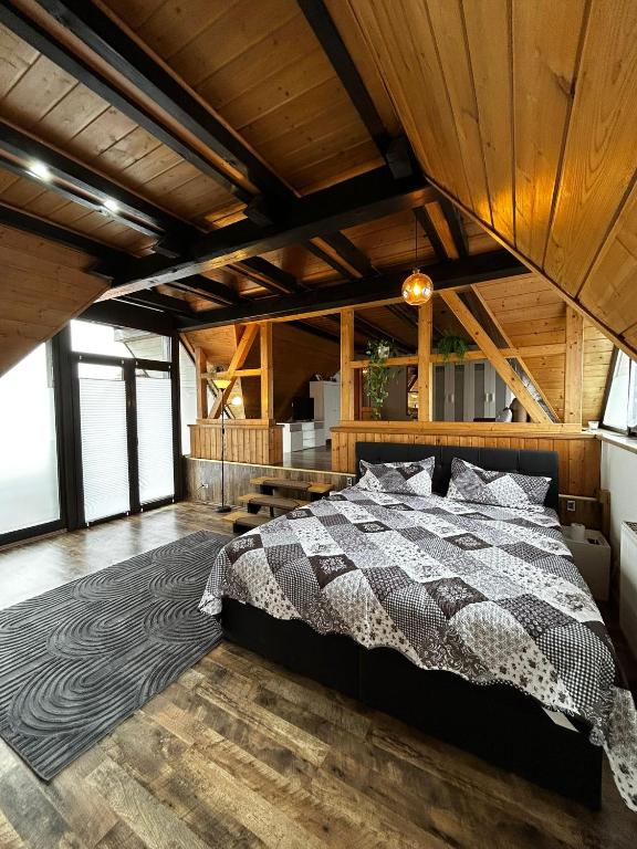 a bedroom with a bed in a room with wooden ceilings at Haus Anna in Oberdachstetten