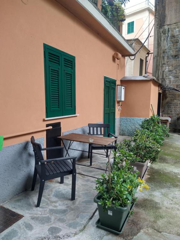 a patio with two benches and green shutters at Casa nonna Gina in Genoa