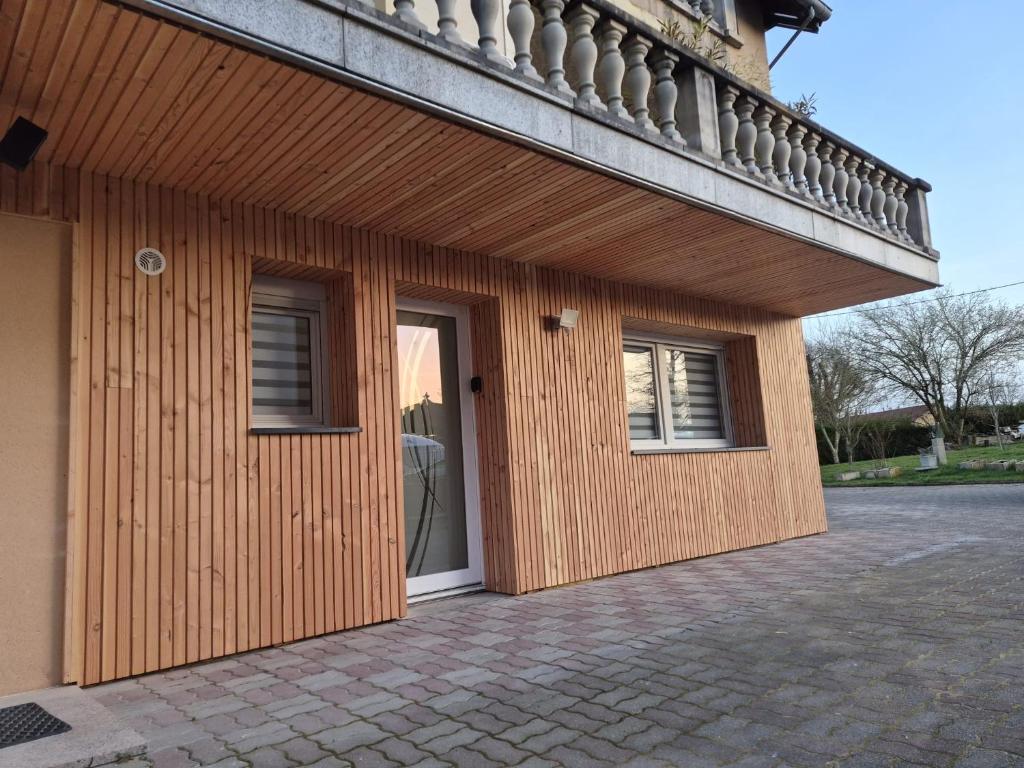 a building with a door and a balcony at Cottage des Lacs in Puttelange-aux-Lacs