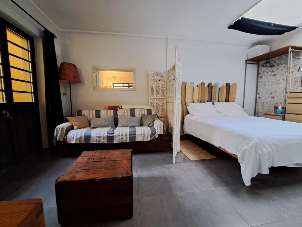 a bedroom with a large bed and a couch at Il TRE del TRENTA in Turin