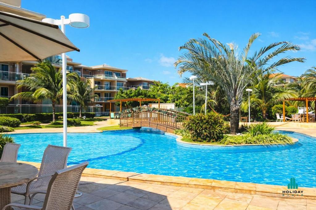 a pool at a resort with a table and chairs at Palm Beach 206 BL 4 by Holiday Stays in Aquiraz