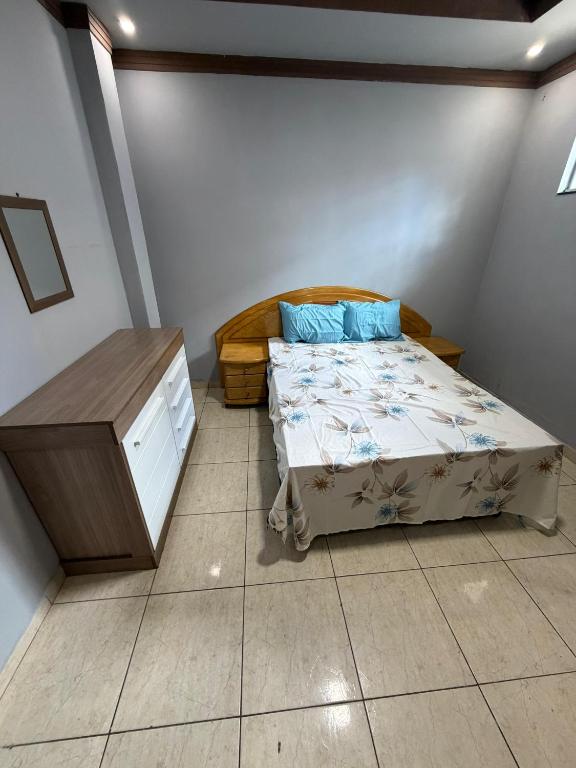 a small bedroom with a bed and a dresser at Casa Ibirapuera in Vitória da Conquista