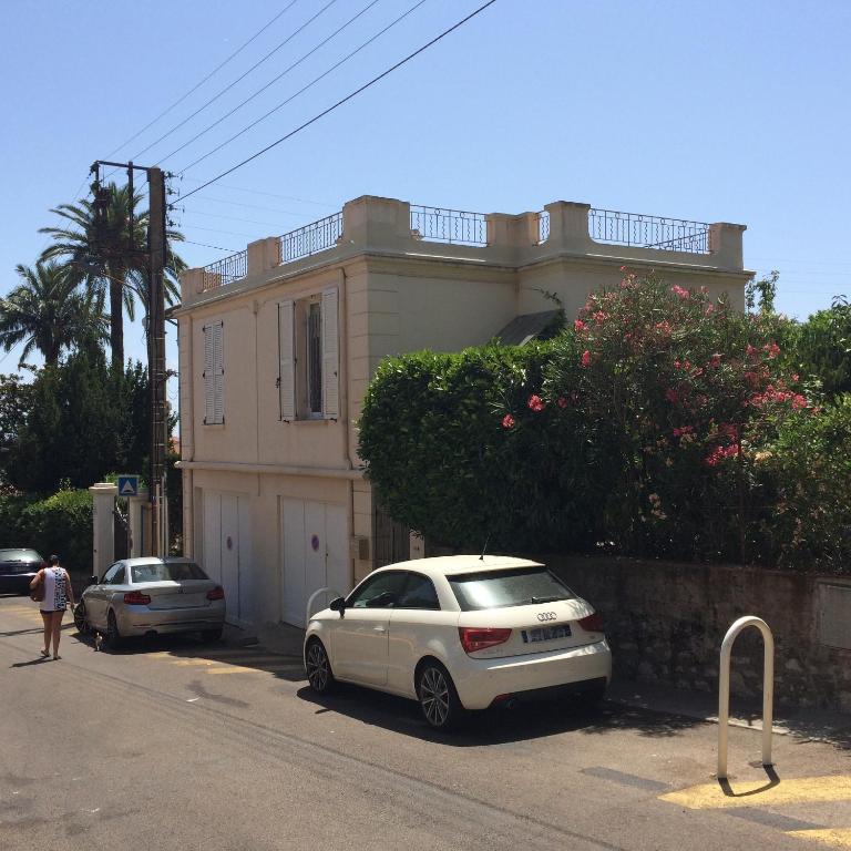 Maison palm في كان: سيارة بيضاء متوقفة أمام منزل