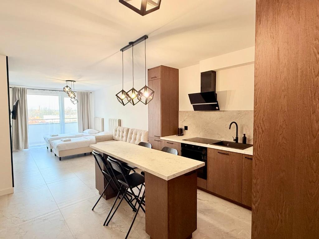 a kitchen and living room with a table and chairs at Drahan Apartment 38 in Radom