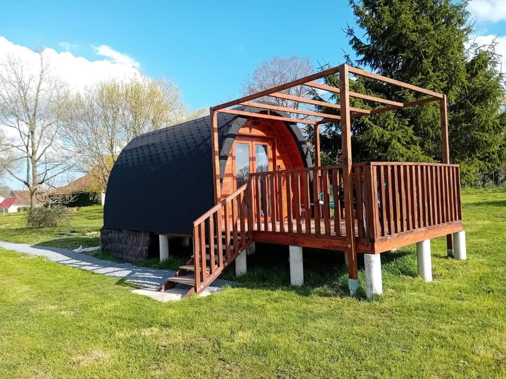 a house with a deck on the grass at L'Escapade dans les Prés in Les Pégués