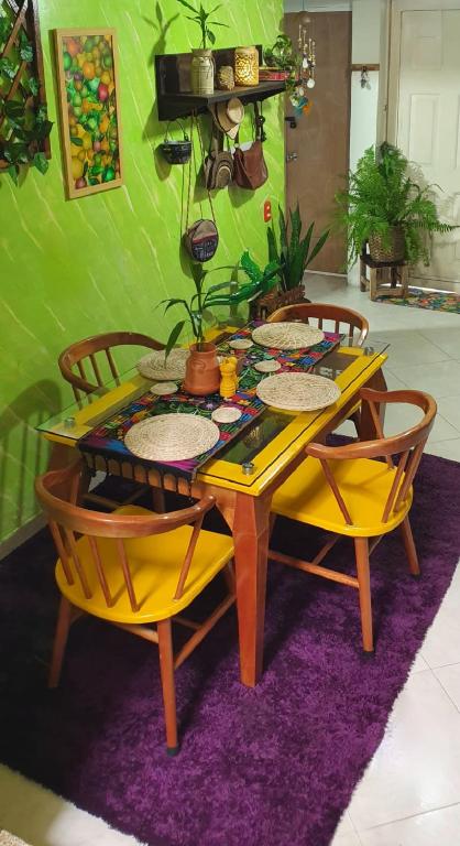 a yellow table with chairs and plates on it at Antigua Hostal in Bucaramanga