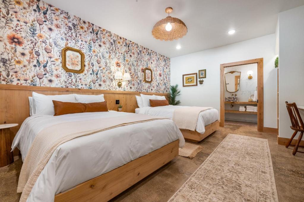 two beds in a bedroom with floral wallpaper at Sommer House Inn-Garden Room in Jasper