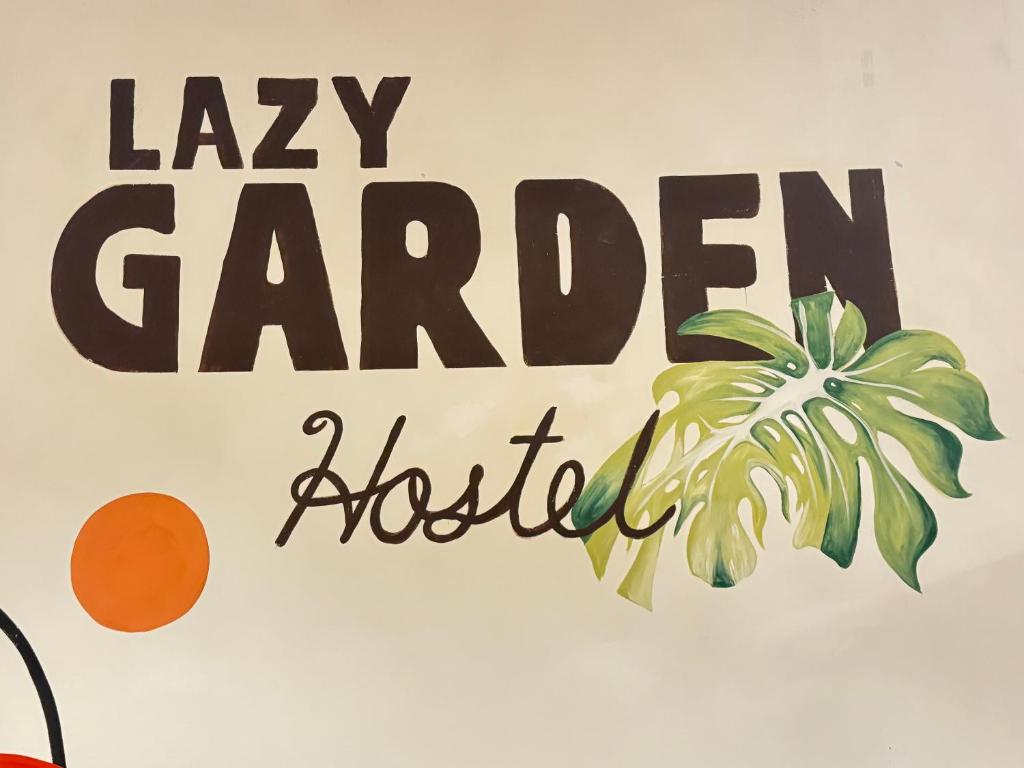 a sign for a garden hospital with a palm tree at Lazy Garden Hostel in Phra Ae beach