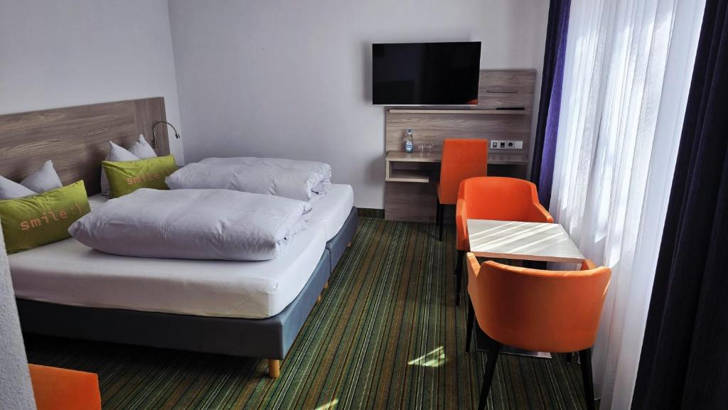 a hotel room with a bed and a tv at Gästehaus König in Weinstadt
