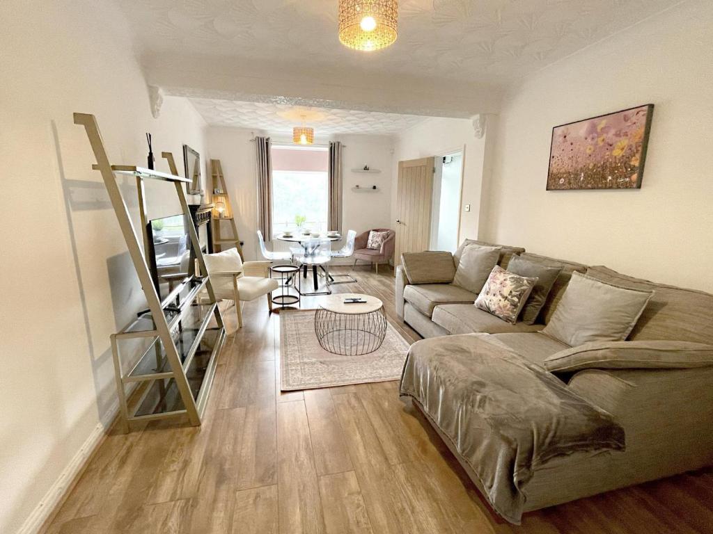a living room with a couch and a table at Pleasant View Cottage in Trehafod