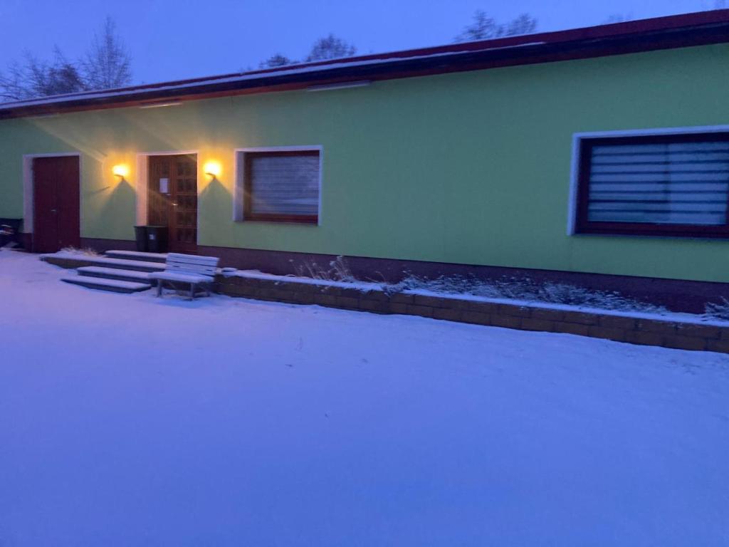 a building with two benches in front of it at Hei un Urlaub in Neu Damerow