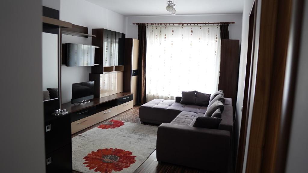 a living room with a couch and a television at Apartament 2 camere SIBIU-SELIMBAR in Şelimbăr