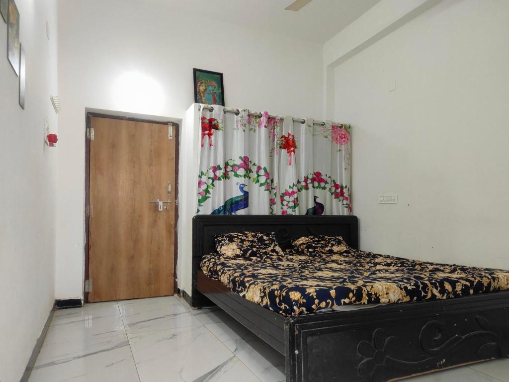 a bedroom with a bed with a curtain and a door at SRI PADMAVATHI NiVAS in Pithāpuram