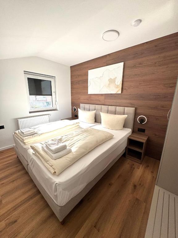 a bedroom with a large bed with wooden walls at Apartments Rosenstraße in Soltau