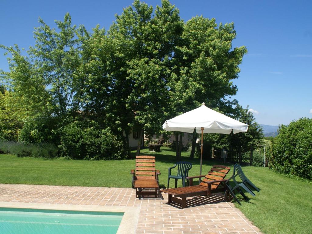 a group of chairs and an umbrella next to a pool at Holiday Home in Montone with Pool & Terrace in Montone