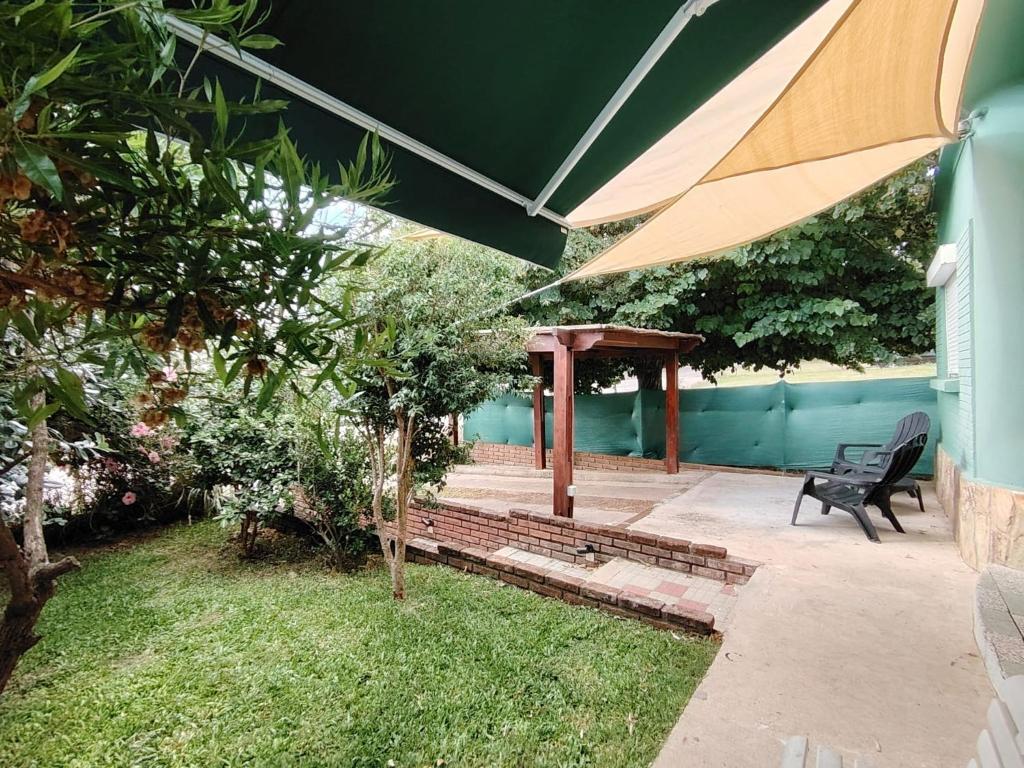 a patio with a bench and an umbrella at Casa Uruguay in Piriápolis