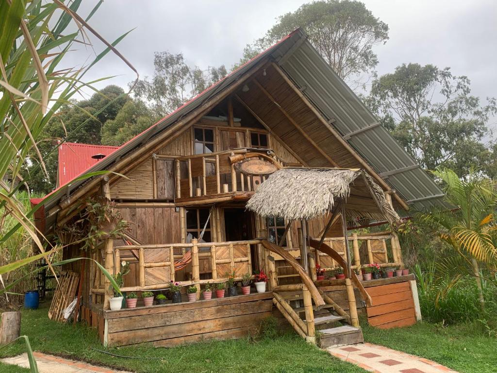 a small house with a thatched roof at Cabaña Dos Búhos in Murillo