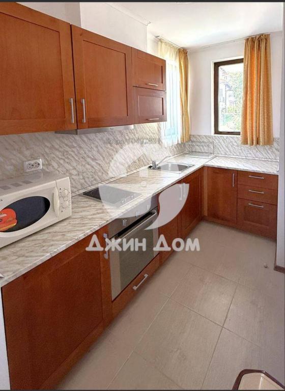a kitchen with wooden cabinets and a microwave at Dimi's Bay View Villas in Kosharitsa