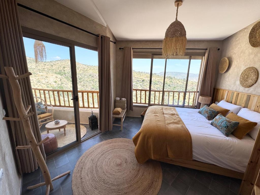 a bedroom with a large bed and a balcony at Manapany Surf Camp in Tamraght Ouzdar