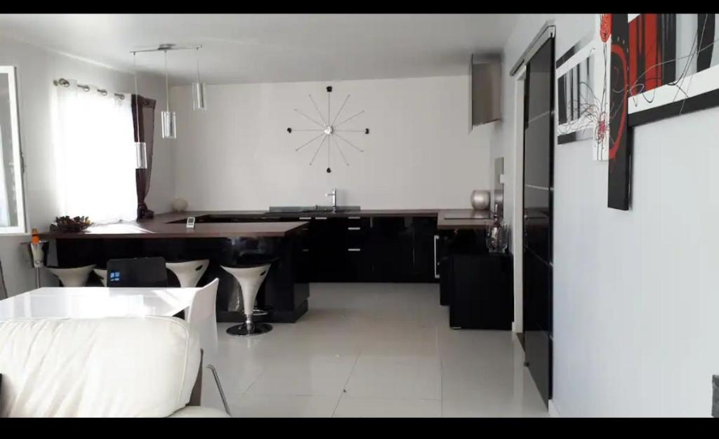 a kitchen with a large clock on the wall at Porte de Paris in Saclay