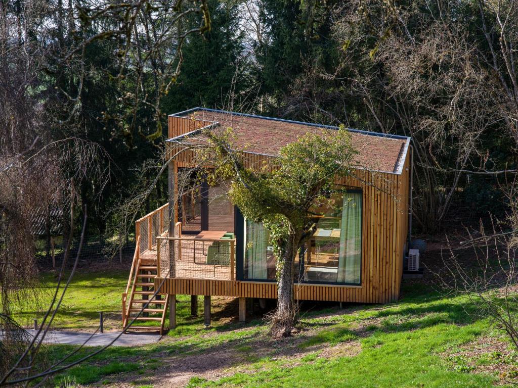 a tiny house with a staircase and a tree at Chez Oreste - Escapade à 2 avec sauna et jardin clos in Aywaille
