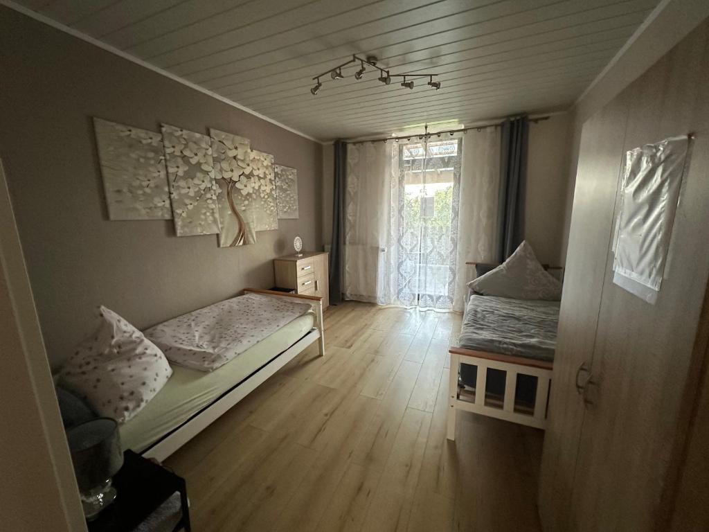 a small room with two beds and a window at Palminas Monteur FeWo EG in Merzig
