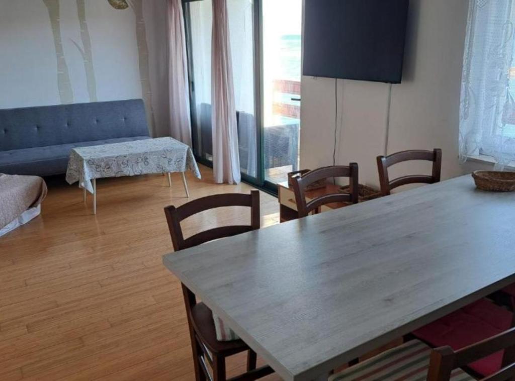 a living room with a wooden table and chairs at Stomorska Seaside Apartments in Stomorska