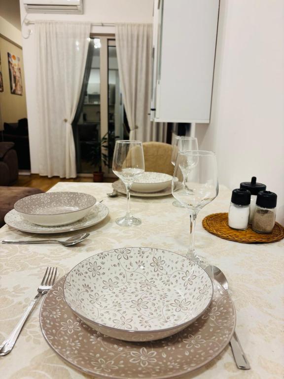 a table with plates and wine glasses on it at Sunshine in Budva
