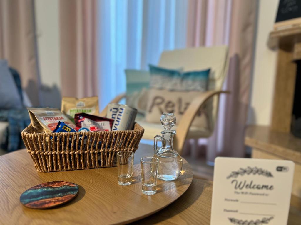 a table with a basket and a bottle and glasses at Aurora Luxury Apartment in Keramoti