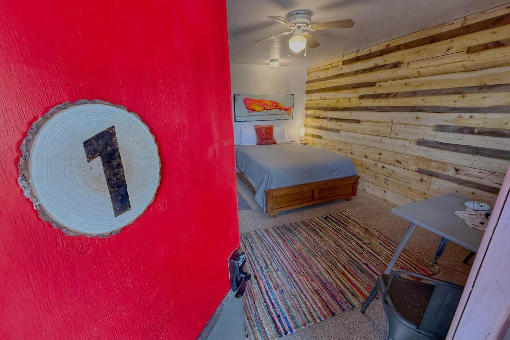 a bedroom with a red wall with a bed and a mirror at Salish Queen Mokee Shared Kitchen Pets OK! #1 in Bluff