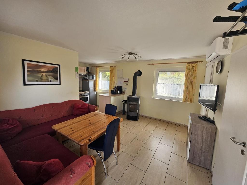a living room with a red couch and a wooden table at Haus am Waldesrand in Wustrow