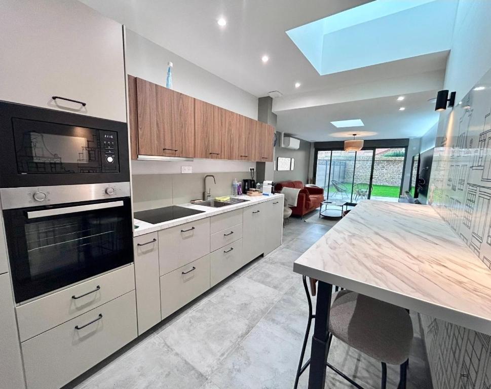 a kitchen with white cabinets and a counter top at Plain-pied accès facile idéal séjour tranquille in Bailleul