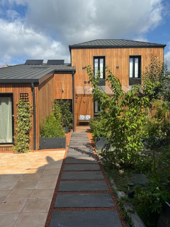a wooden house with a pathway leading to it at Chalet urbain-150m2 jardin privatif-15mn de Paris in Le Bourget