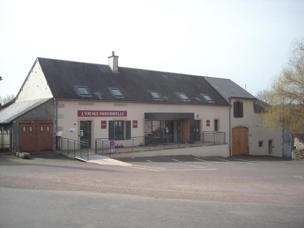 a large white building with a black roof at L 'Escale Morvandelle in Saint-Brisson