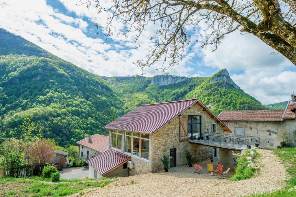 a stone house with mountains in the background at Retraites & Séminaires, Spa, La Ressource Malix 15 personnes in Tenay