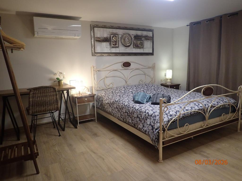 a bedroom with a bed and a table and a chair at Chambre Privée avec Sauna in Villeneuve-Loubet