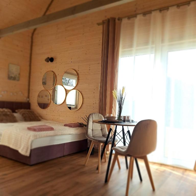 a bedroom with a bed and a table and chairs at Leśny Reset 2 in Grabowo