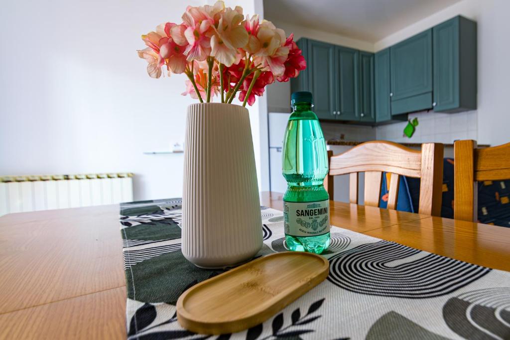 a vase of flowers and a bottle on a table at Binario 22 in San Gemini