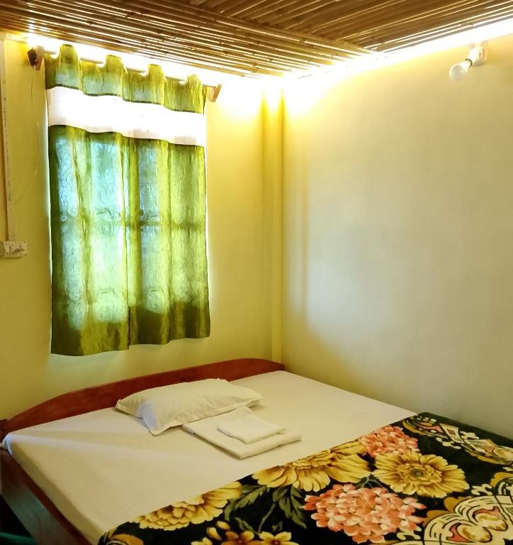 a small bedroom with a bed and a window at Meghh Minar Homestay Sillery Gaon in Kalimpong