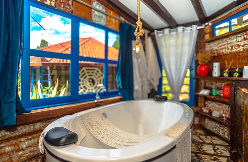 a bath tub in a room with a window at OctoCabana com banheira e mirante privativo in Urubici